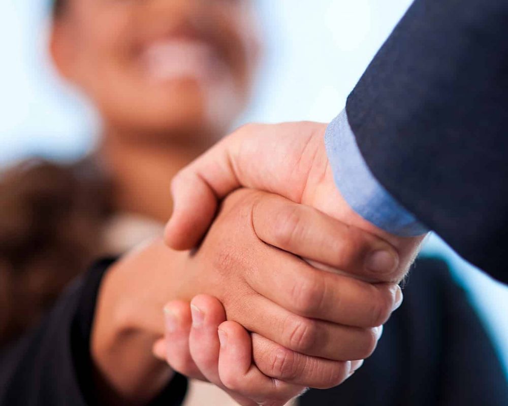 A handshake between business people Image of two business people shaking hands